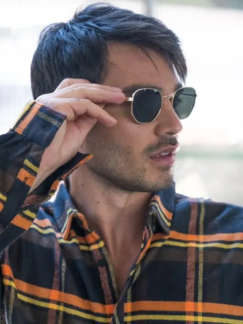 Hombre con anteojos de sol de marco dorado y cristales verdes