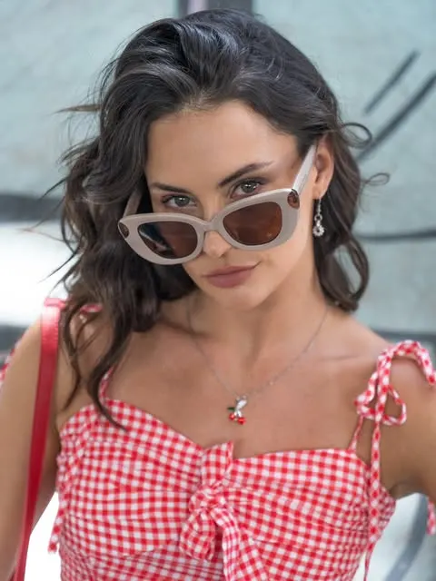 Mujer con anteojos de sol de armazón rosado y cristales marrones
