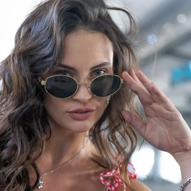 Mujer con anteojos de sol redondos de marco dorado